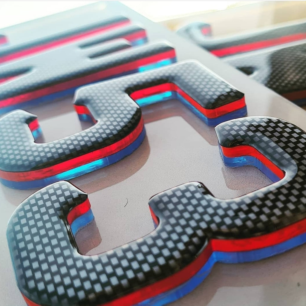 M-Sport Neon 3D Gel plates with a carbon fibre finish